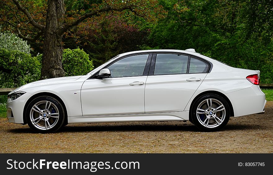 Side of luxury white BMW auto on country road. Side of luxury white BMW auto on country road.