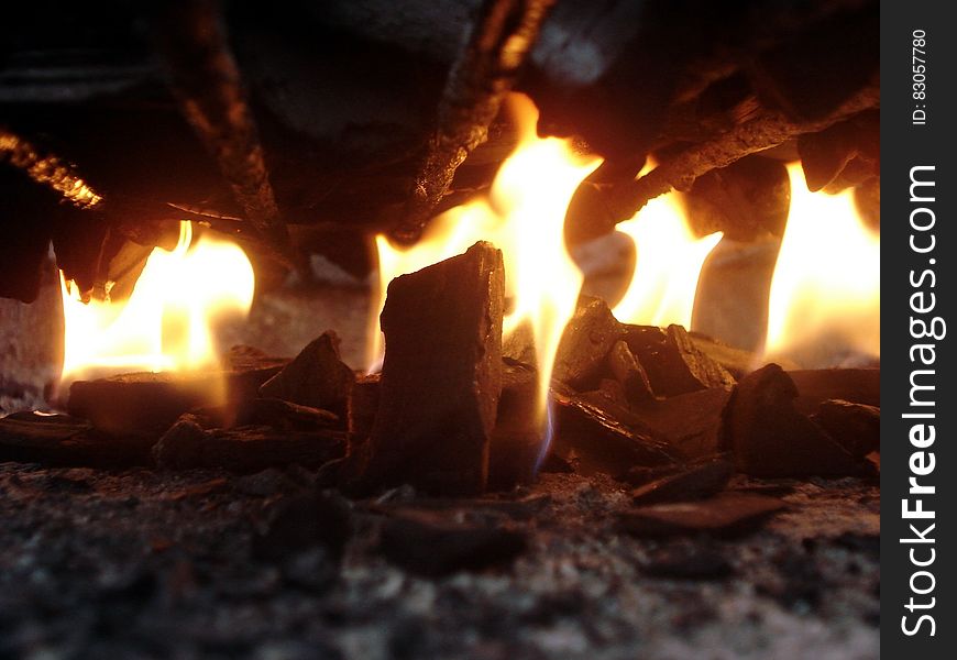 A burning wood fire with red embers and charcoal.