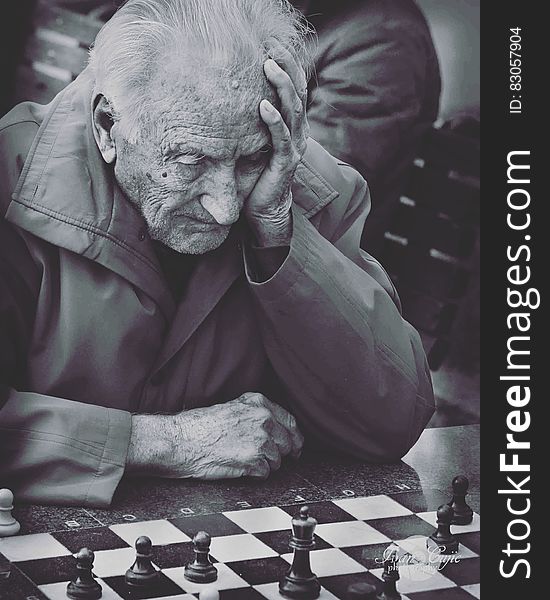 Grayscale Photo of Man Playing Chess