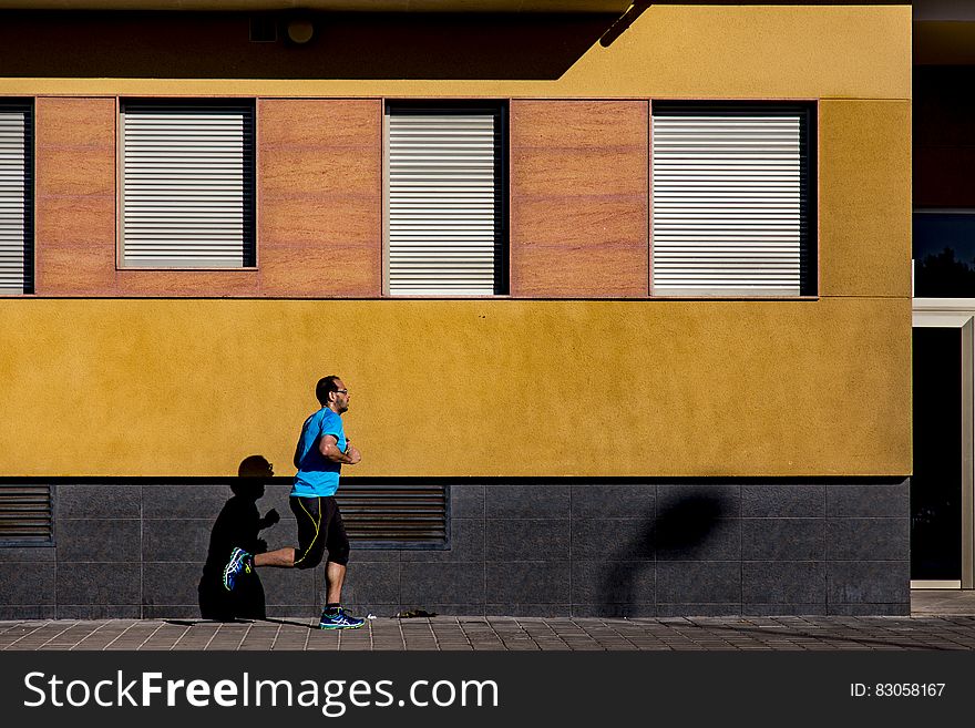 Jogging Man Wearing Blue Shirt during Daytime