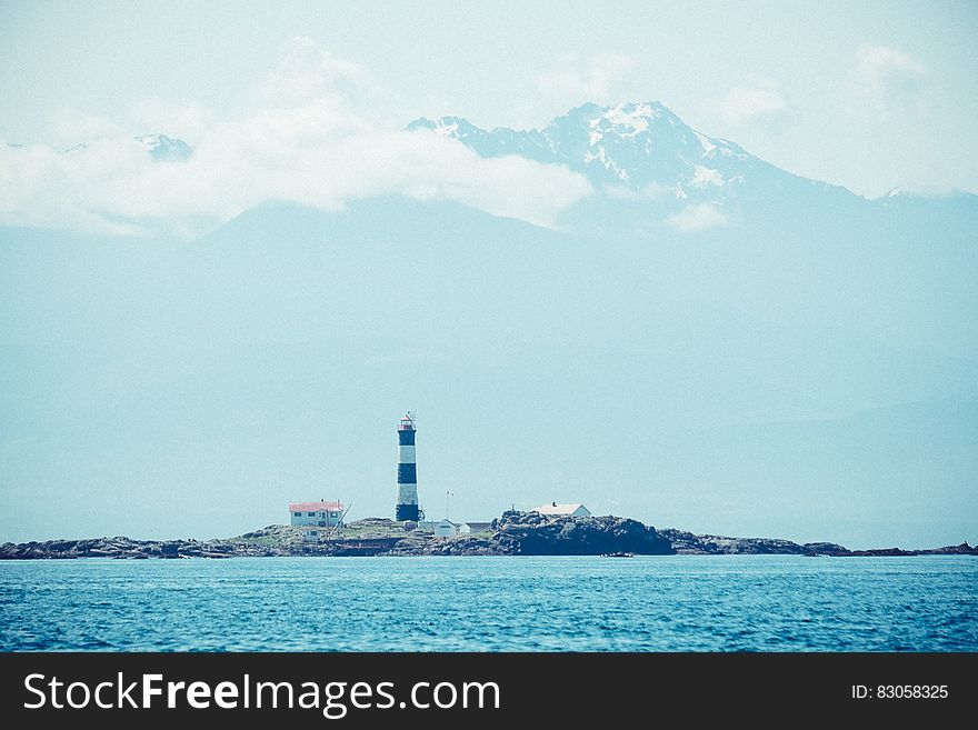 Blue Ocean Near in Black and White Lighthouse during Daytime