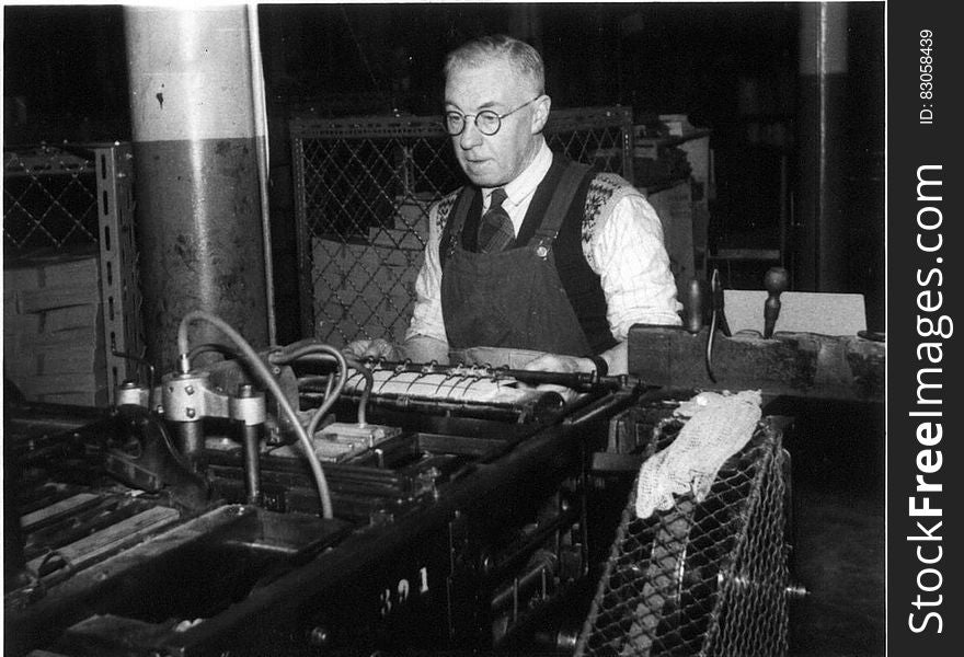 Black and white portrait of mature worker in factory with machinery in foreground. Black and white portrait of mature worker in factory with machinery in foreground.