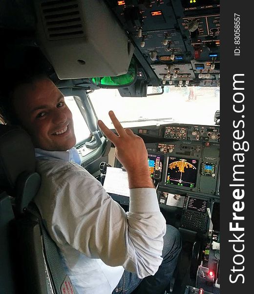 Pilot gesturing and smiling in airplane cockpit. Pilot gesturing and smiling in airplane cockpit.