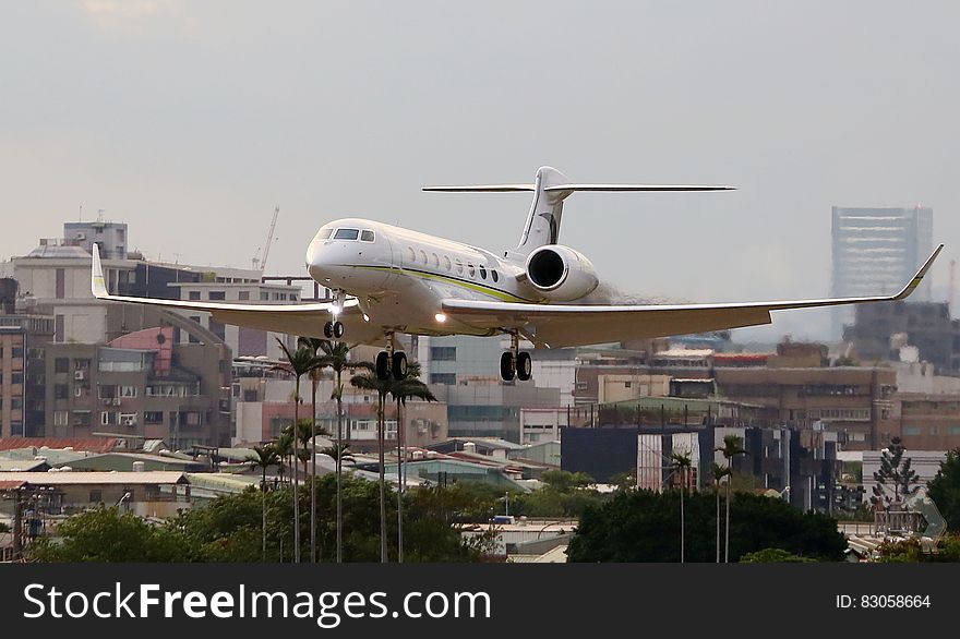 Airplane landing over urban area at airport.