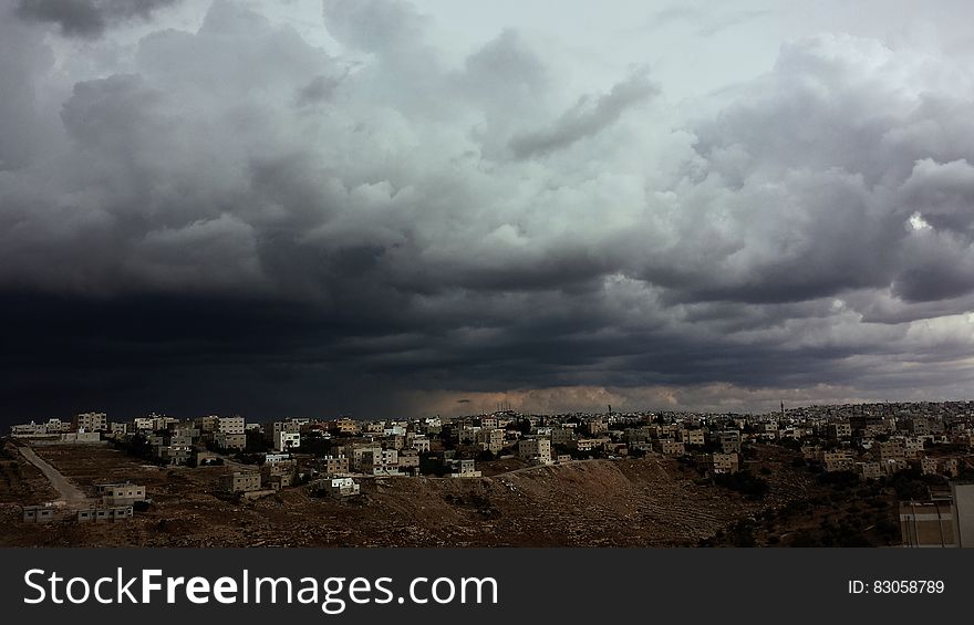 White Concrete Buildings Under Cloudy Sky