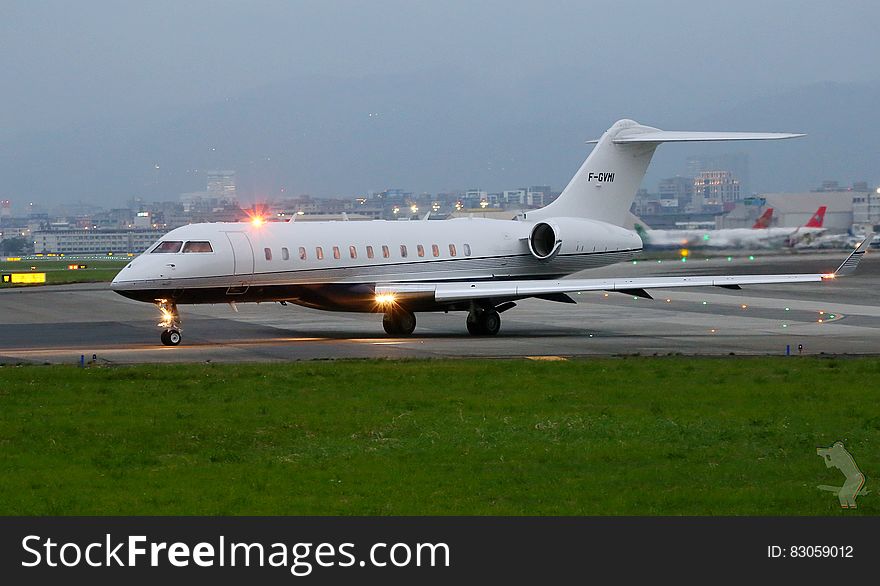 Private jet on taxiway at airport at twilight. Private jet on taxiway at airport at twilight.