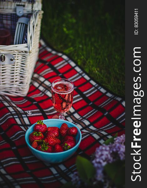 Clear Wine Glass With Wine Near Strawberry Fruit on Red White and Black Plaid Textile