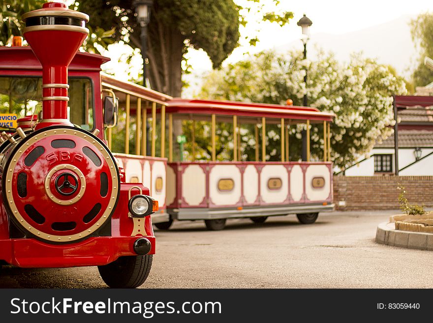 Red and cream tourist train on wheels designed for sight seeing by adults and children.