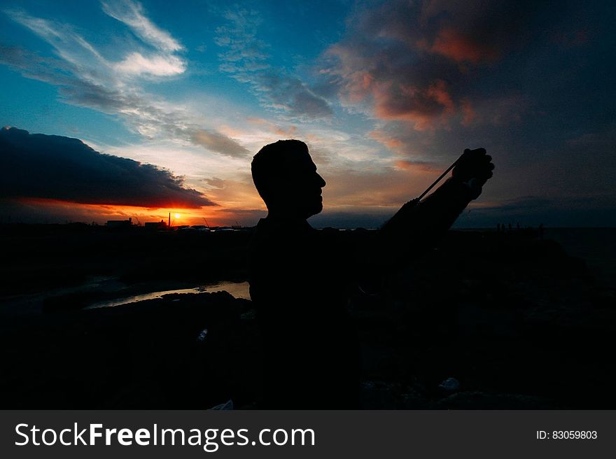 A man taking a selfie at sunset. A man taking a selfie at sunset.