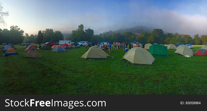 Tents on Green Grass Field Near Mountain