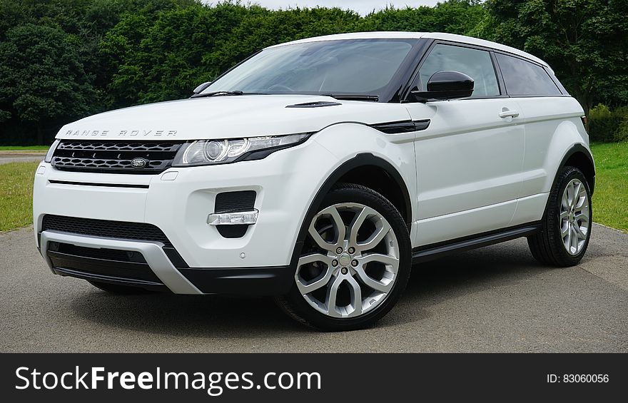 A parked white sport utility vehicle. A parked white sport utility vehicle.