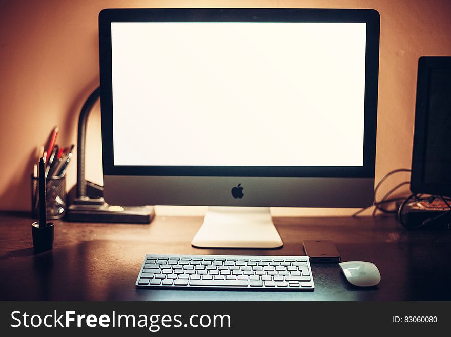 An Apple computer with an empty white monitor background. An Apple computer with an empty white monitor background.