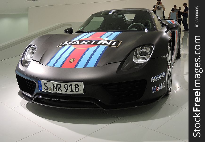A black Martini Porsche racing car as an exhibit in a museum.