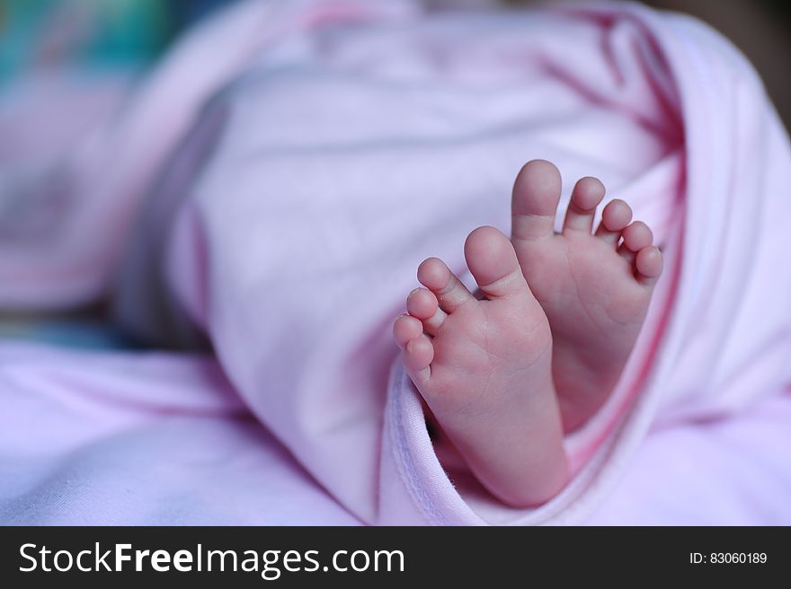 White Bed Spread Near A Human Foot During Night Time