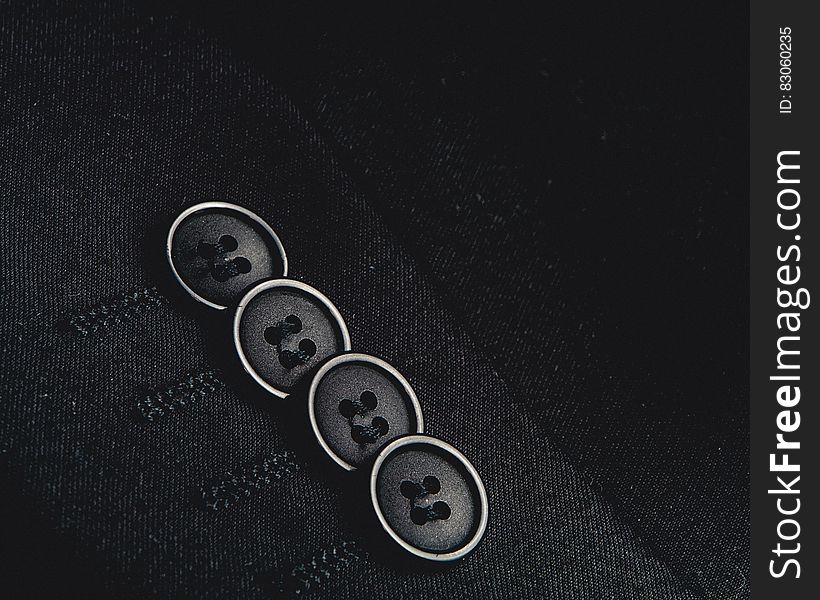 Close up of buttons on tailored sleeve in black and white. Close up of buttons on tailored sleeve in black and white.