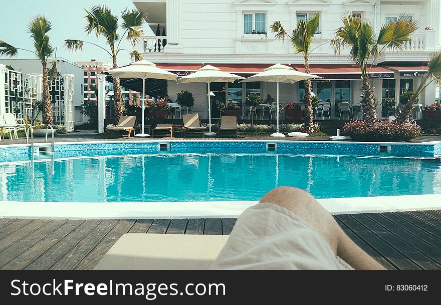 Person Relaxing Near a Swimming Pool