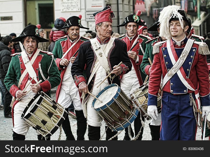 Men playing vintage drums in costumes in military recreation on streets on sunny day. Men playing vintage drums in costumes in military recreation on streets on sunny day.