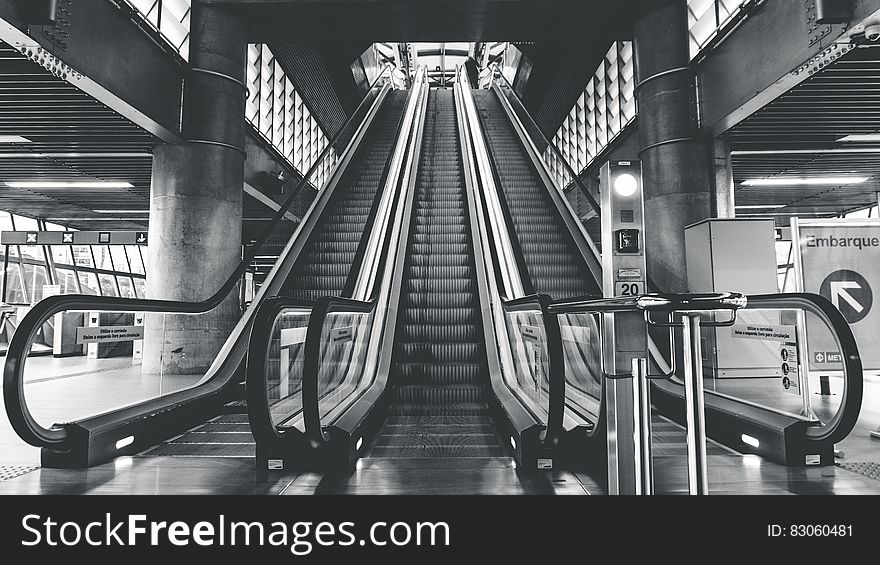 Black and white view looking to top of escalators in modern building. Black and white view looking to top of escalators in modern building.