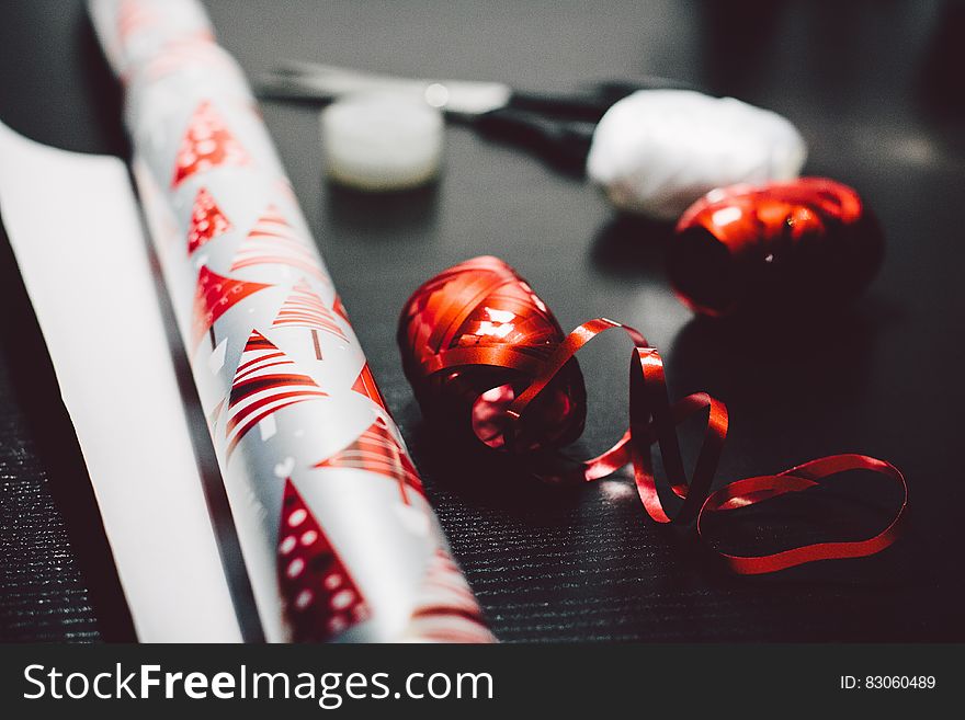 Close up of roll of Christmas wrapping paper with ribbons.