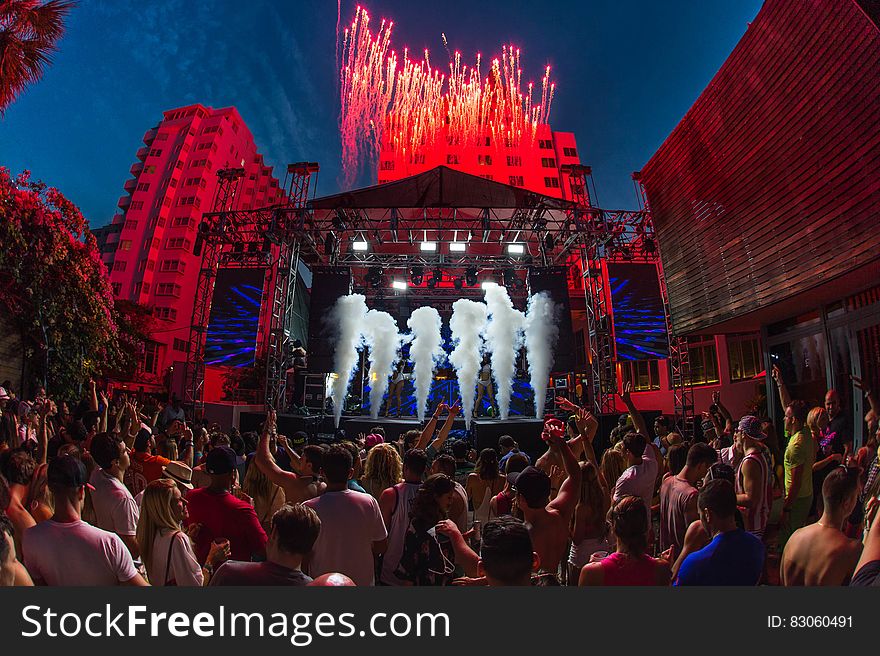 Concert goers in outdoor plaza in front of stage at night. Concert goers in outdoor plaza in front of stage at night.