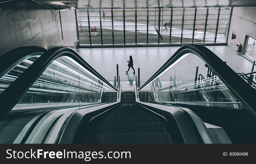 Escalator in sunny atrium in modern building. Escalator in sunny atrium in modern building.