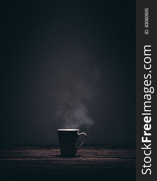 Coffee cup with steam on wooden tabletop with copy space. Coffee cup with steam on wooden tabletop with copy space.