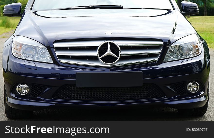 Blue mercedes Sedan Near Green Grass Field during Day Time