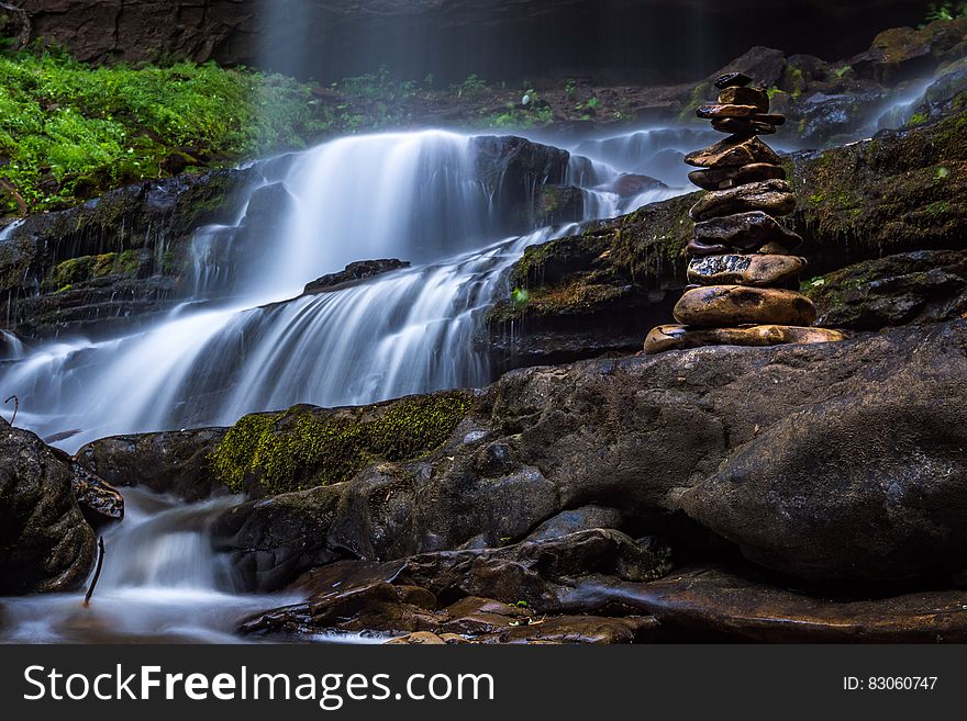 Waterfall in the form of a cascade with boulders placed at the right hand side and a mossy bank on the left. Waterfall in the form of a cascade with boulders placed at the right hand side and a mossy bank on the left.