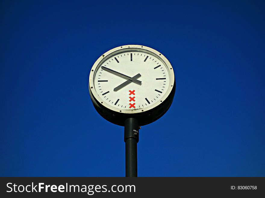 White and Black Round Top Analog Pedestal Clock Low Angle View