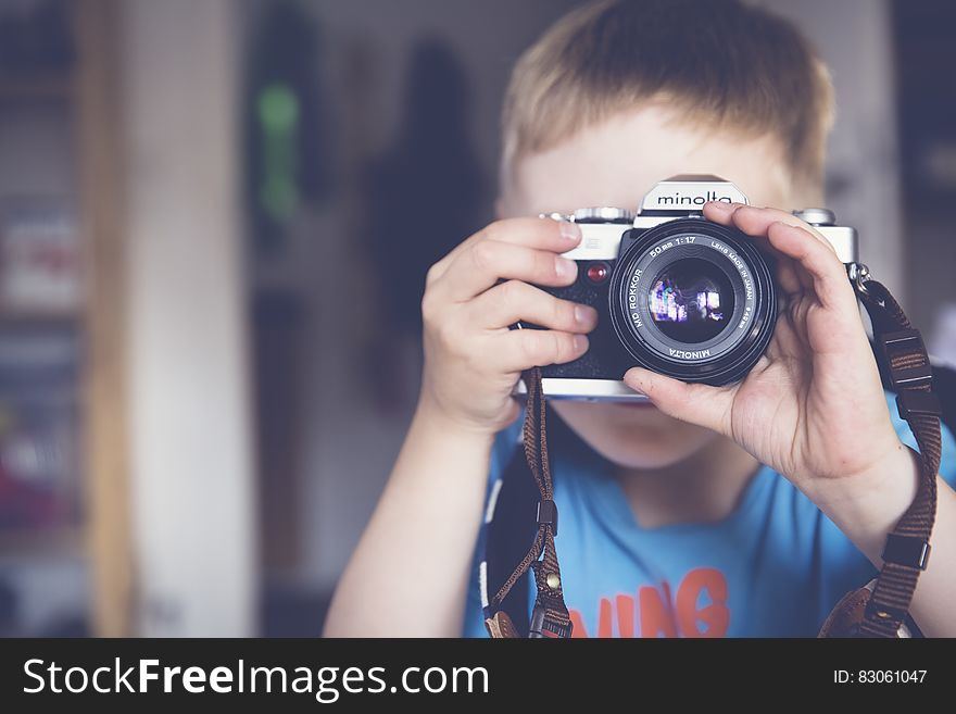 Boy In Blue Crew Neck T Shirt Taking Photo Using Minolta Dslr Camera During Daytime