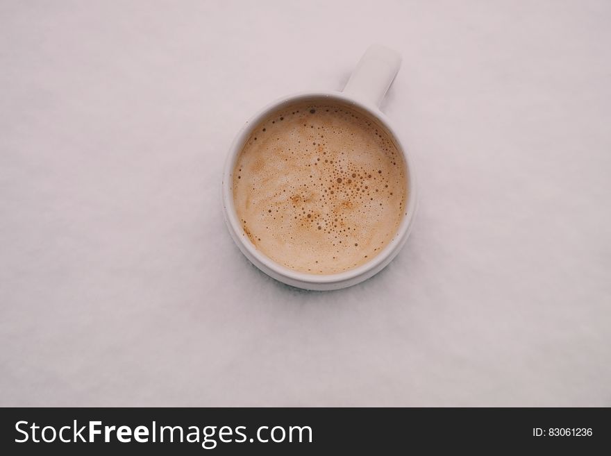 A cup of espresso with milk on a white background.