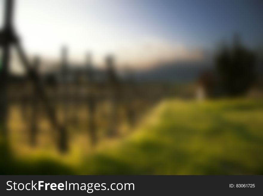 A blurred landscape with green field and blue sky. A blurred landscape with green field and blue sky.