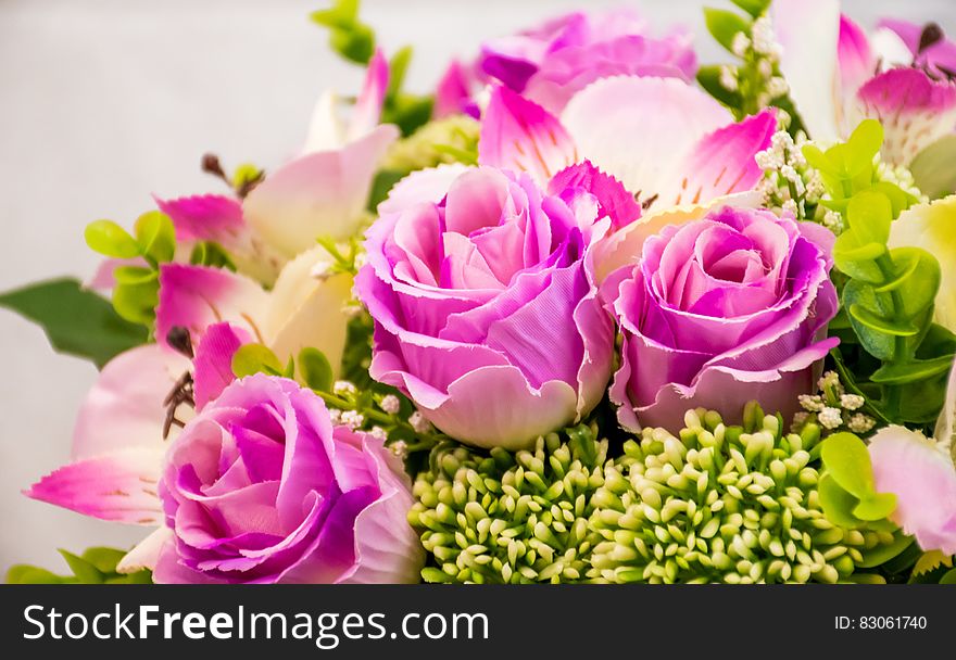 A close up of a flower arrangement with pink roses.