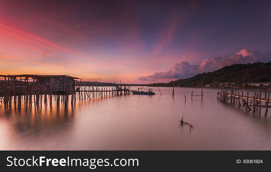 A beach with wooden pier at sunset. A beach with wooden pier at sunset.