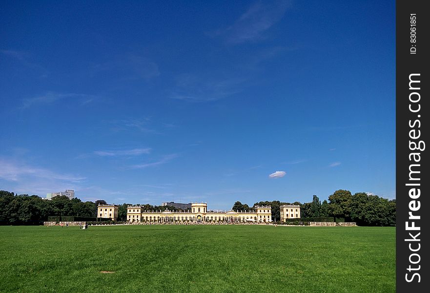 Mansion on green lawn at Karlsaue Park in Kassel, Germany with blue skies on sunny day. Mansion on green lawn at Karlsaue Park in Kassel, Germany with blue skies on sunny day