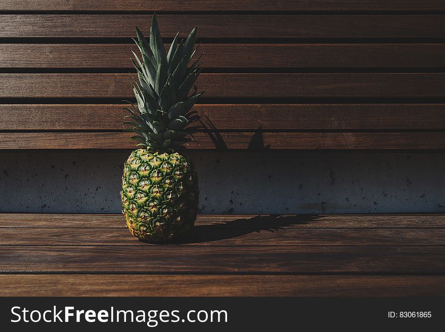 Fresh ripe whole pineapple fruit on wooden bench. Fresh ripe whole pineapple fruit on wooden bench.
