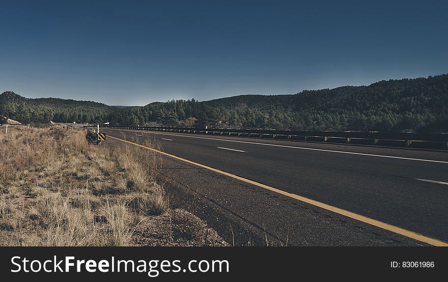 Empty road through countryside on sunny day.