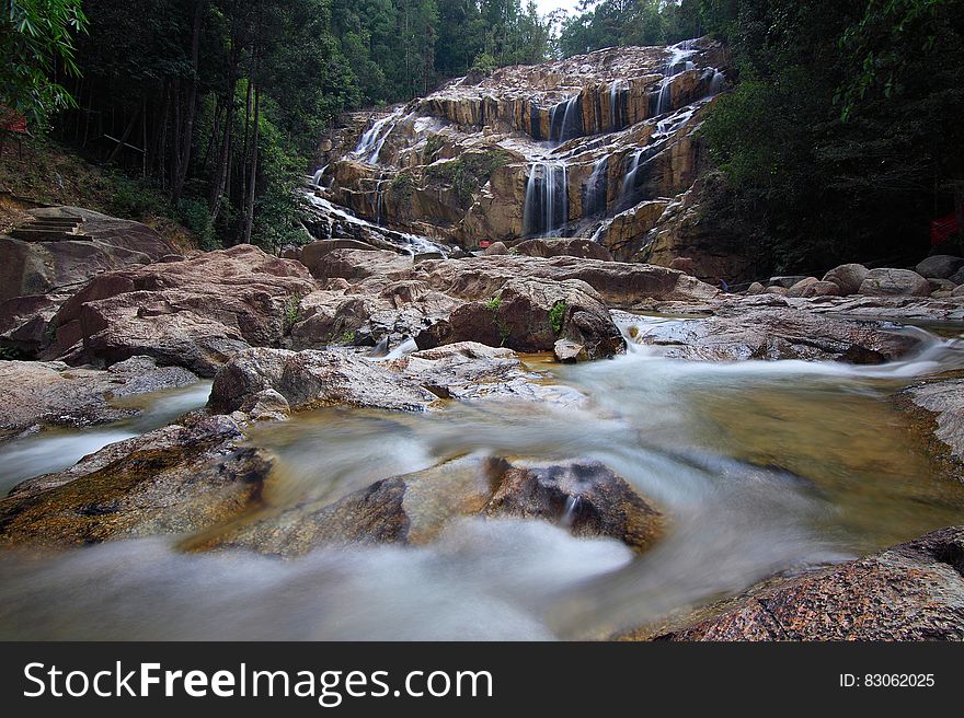 Waterfall over cliff and rocky stream in forest. Waterfall over cliff and rocky stream in forest.