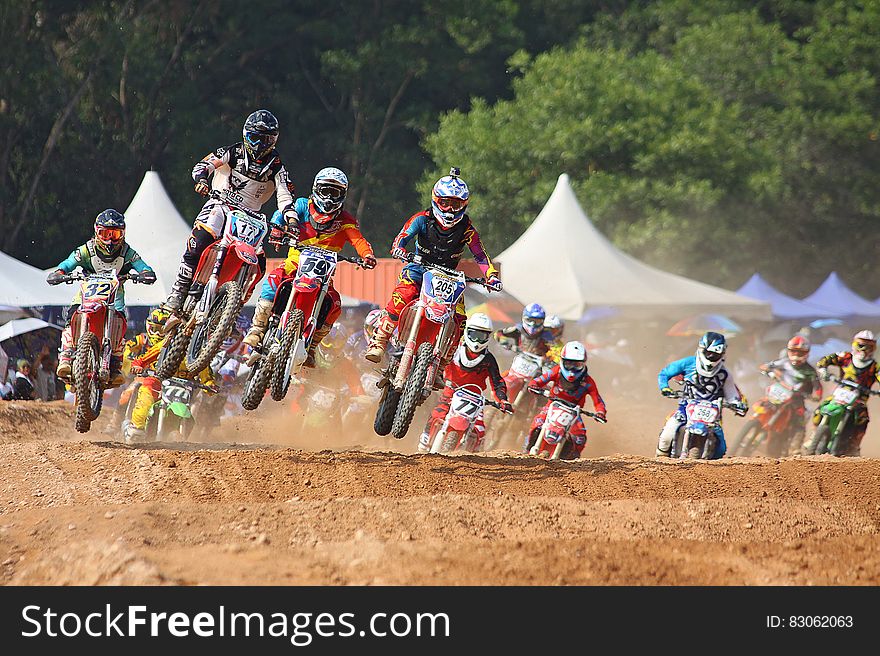 Motocross bikers crossing an obstacle on the track. Motocross bikers crossing an obstacle on the track.