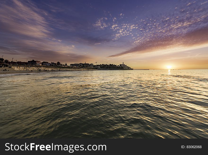 An evening at the sea with the sun setting behind the horizon. An evening at the sea with the sun setting behind the horizon.