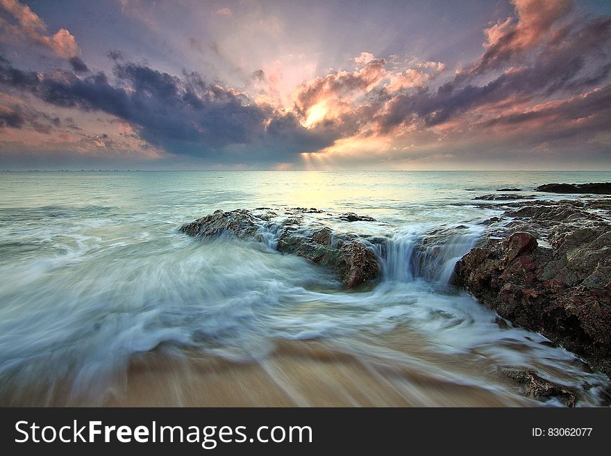 A long exposure on a rocky shore with sunset. A long exposure on a rocky shore with sunset.