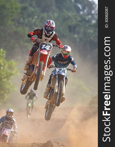A motocross race with motorbikers jumping over an obstacle. A motocross race with motorbikers jumping over an obstacle.