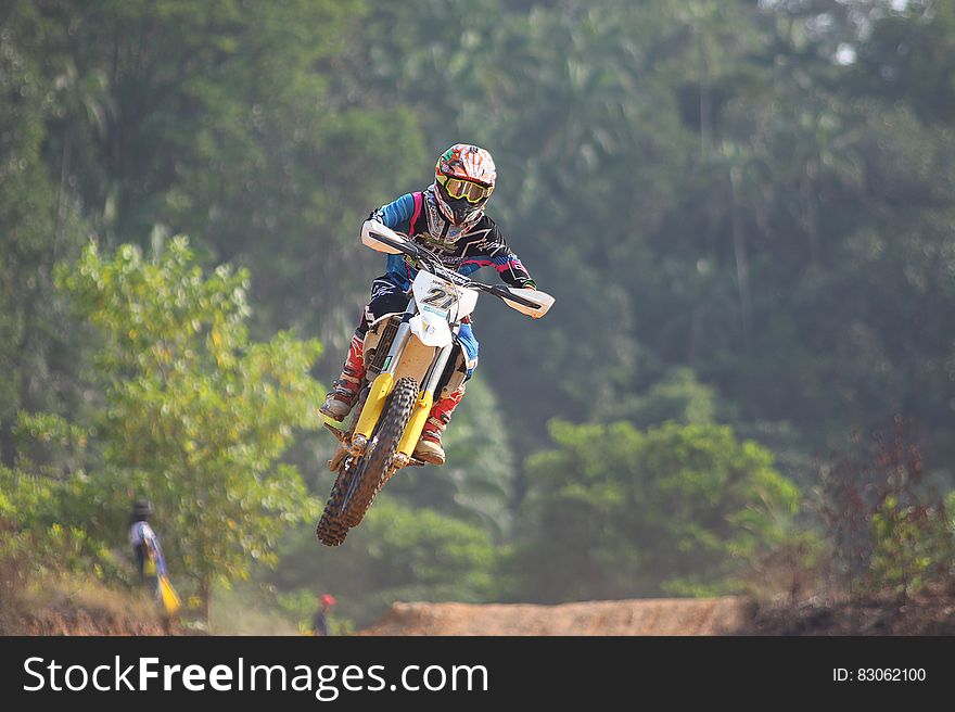 A motocross racer jumping over an obstacle.