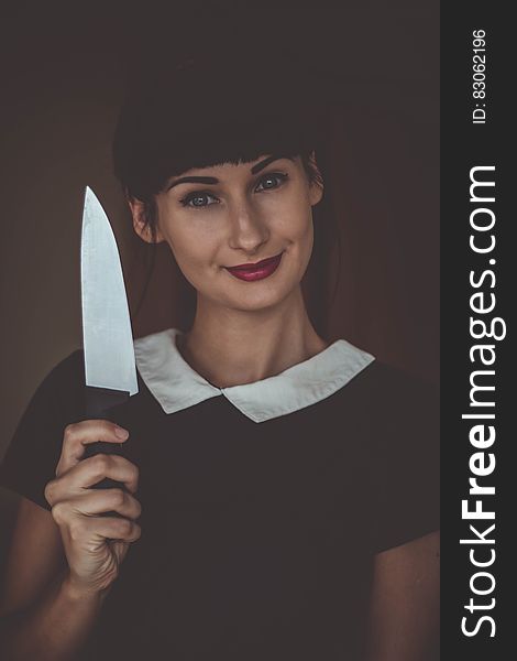 A woman holding a kitchen knife. A woman holding a kitchen knife.
