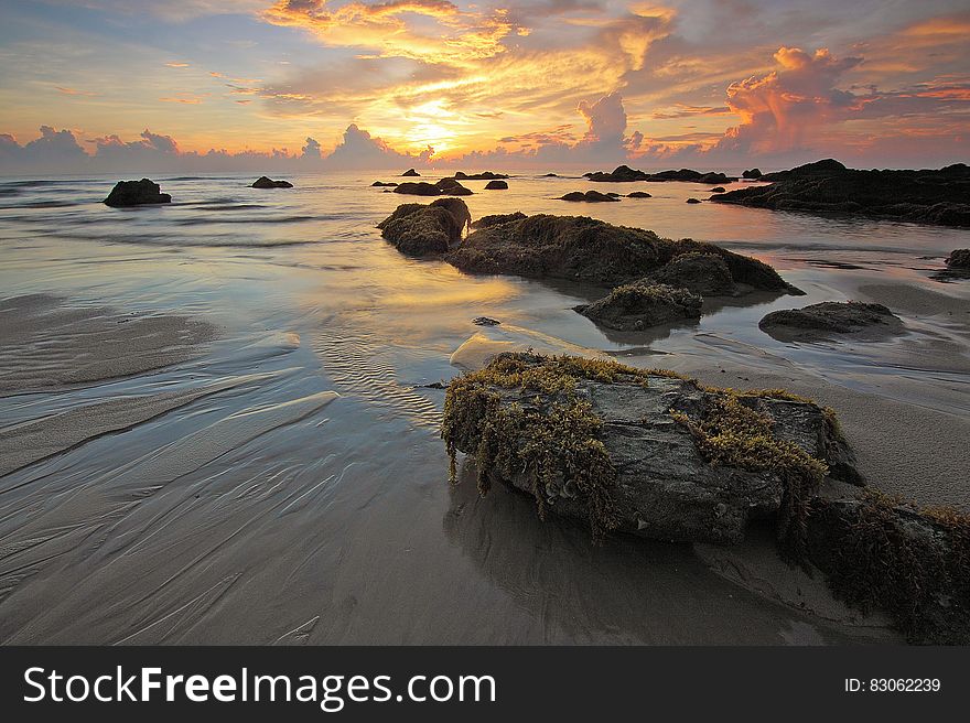 Sea Rock Under White Clouds Blue Skies during Sunset