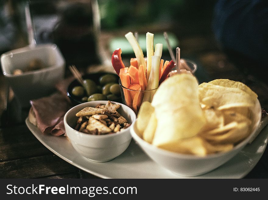 Tray of bowls with chips, snack mix, olives and crudites. Tray of bowls with chips, snack mix, olives and crudites.