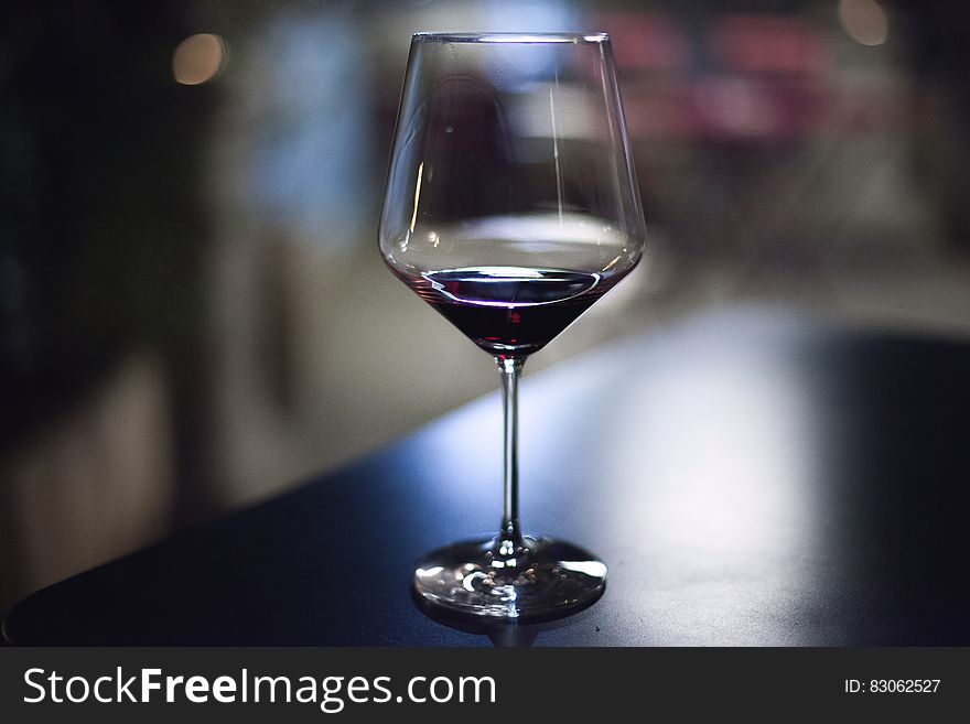 Close up of stemmed wine glass on bar. Close up of stemmed wine glass on bar.
