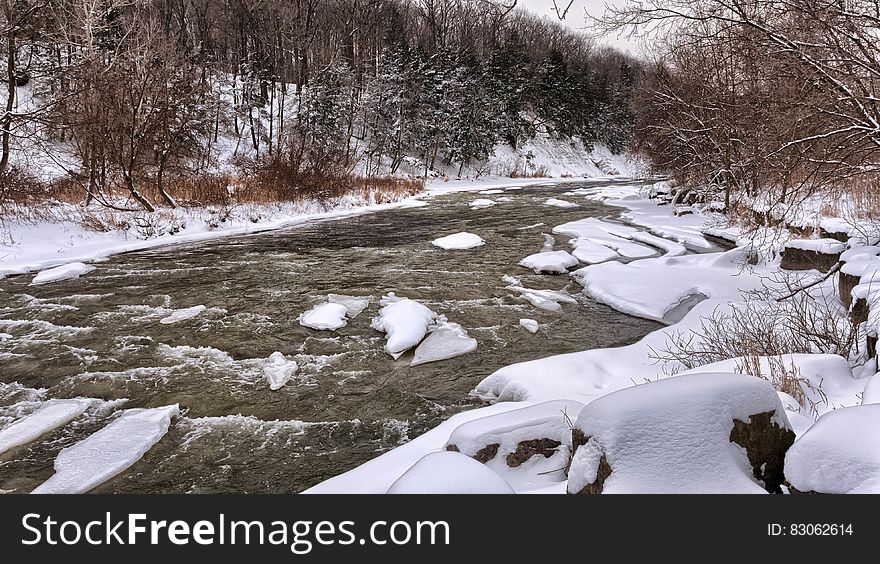 River Beside White Snow during Daytime