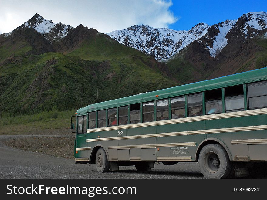 Bus on roadway in mountains on sunny day. Bus on roadway in mountains on sunny day.