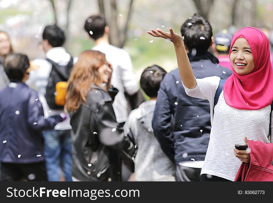 Woman Wearing Red Hijab Behind Person Wearing Black Jacket